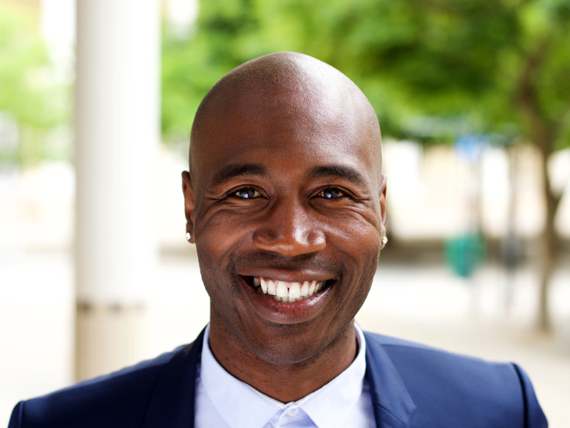 smiling-african-businessman-standing-outdoors-PPMTLXR.jpg